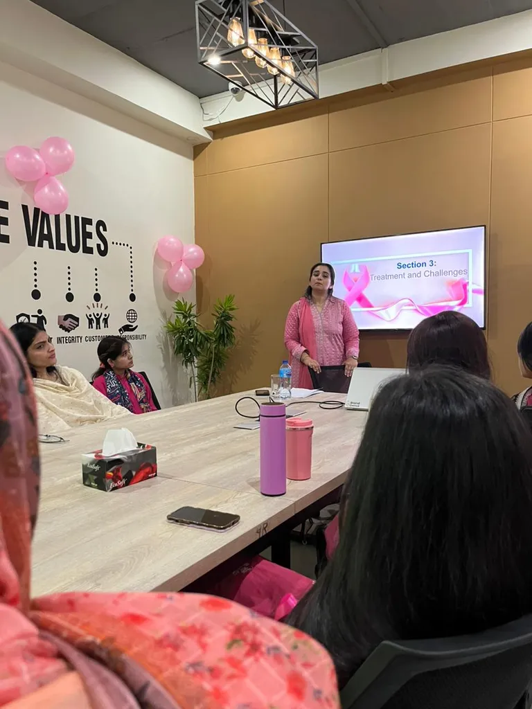 A presenter speaking to seated attendees beneath the values wall