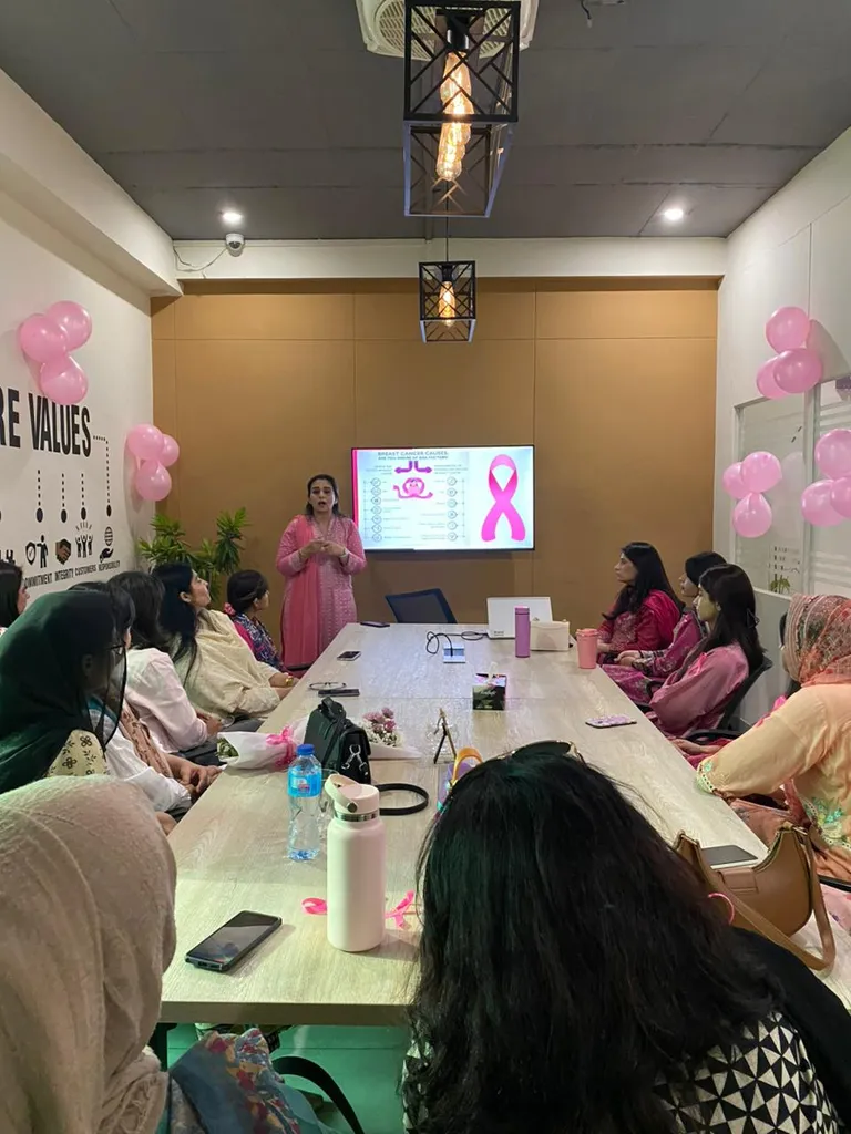 Awareness session with pink balloons and a presenter by the screen