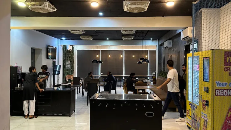 Members at tables in the cafeteria near the foosball corner